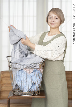 Senior woman doing housework laundry Senior woman doing housework laundry 134658434