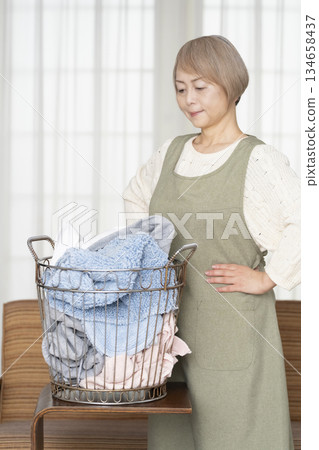 Senior woman doing housework laundry Senior woman doing housework laundry 134658437