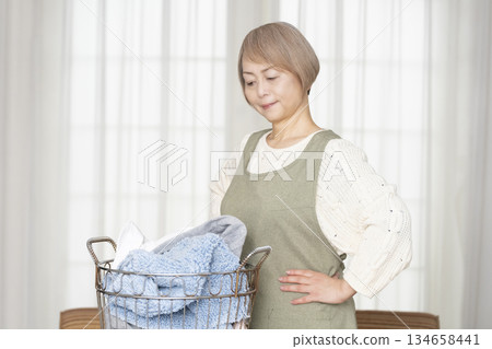 Senior woman doing housework laundry Senior woman doing housework laundry 134658441