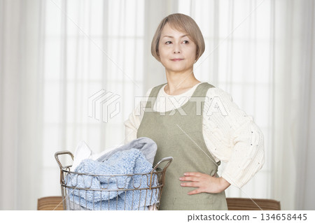 Senior woman doing housework laundry Senior woman doing housework laundry 134658445
