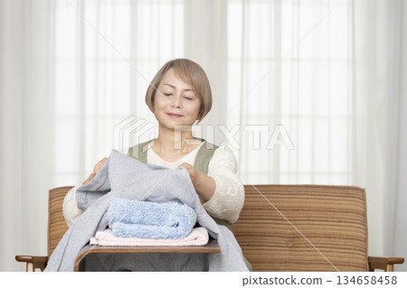 Senior woman doing housework laundry Senior woman doing housework laundry 134658458