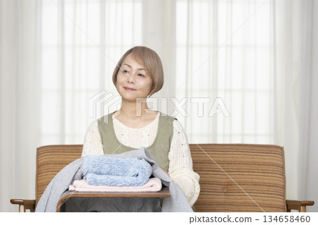 Senior woman doing housework laundry Senior woman doing housework laundry 134658460
