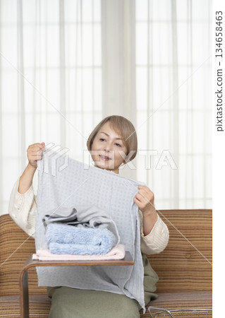 Senior woman doing housework laundry Senior woman doing housework laundry 134658463