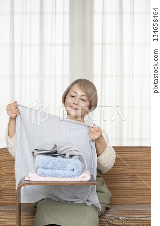 Senior woman doing housework laundry Senior woman doing housework laundry 134658464