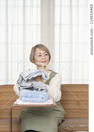 Senior woman doing housework laundry Senior woman doing housework laundry 134658468
