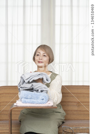 Senior woman doing housework laundry Senior woman doing housework laundry 134658469