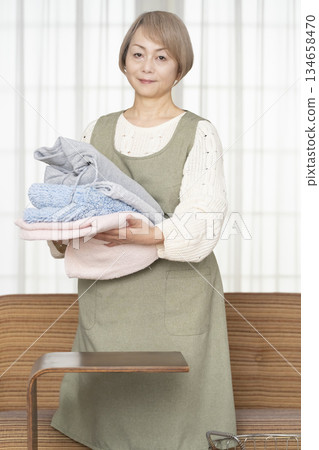 Senior woman doing housework laundry Senior woman doing housework laundry 134658470