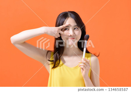 Woman holding a makeup brush 134658587