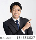 Smiling businessman pointing and guiding 134658627