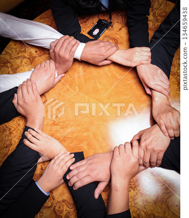 Team Unity, Diverse Hands Joined Together Around Wooden Table in Collaborative Meeting showcasing good teamwork, support and collaboration 134659438