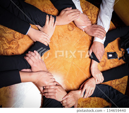 Team Unity, Diverse Hands Joined Together Around Wooden Table in Collaborative Meeting showcasing good teamwork, support and collaboration Team Unity, Diverse Hands Joined Together Around Wooden Table in Collaborative Meeting showcasing good teamwork, support and collaboration 134659440