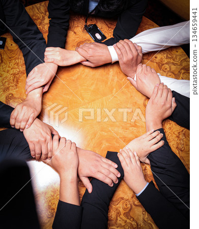 Team Unity, Diverse Hands Joined Together Around Wooden Table in Collaborative Meeting showcasing good teamwork, support and collaboration Team Unity, Diverse Hands Joined Together Around Wooden Table in Collaborative Meeting showcasing good teamwork, support and collaboration 134659441