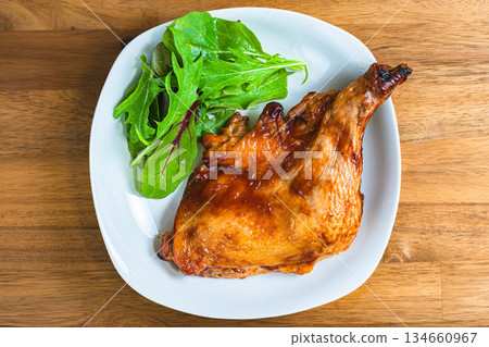 Roast chicken served on a white plate on a wooden table Roast chicken served on a white plate on a wooden table 134660967