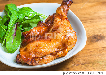 Roast chicken served on a white plate on a wooden table Roast chicken served on a white plate on a wooden table 134660971