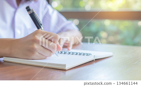 AI Image: Close-up of a person taking notes in a notebook 134661144
