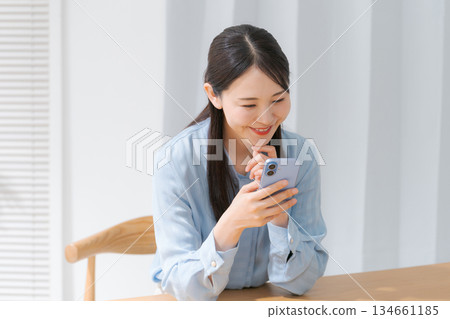 Young woman looking at a smartphone Young woman looking at a smartphone 134661185