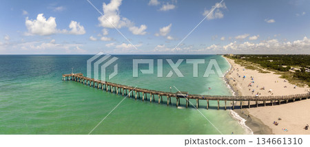 Summer landscape at Venice fishing pier in Florida. Ocean surf waves crashing on warm sandy beach Summer landscape at Venice fishing pier in Florida. Ocean surf waves crashing on warm sandy beach 134661310