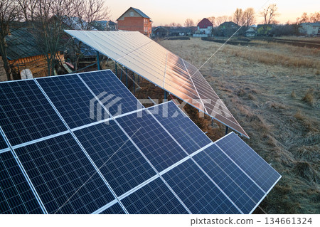 Solar photovoltaic panels for producing of clean ecological electrical energy mounted on backyard ground in suburban rural area. Concept of autonomous home Solar photovoltaic panels for producing of clean ecological electrical energy mounted on backyard ground in suburban rural area. Concept of autonomous home 134661324