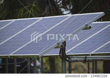 Solar panels installed on stand frame near parking lot for effective generation of clean electricity. Photovoltaic technology integrated in urban infrastructure for electric car charging Solar panels installed on stand frame near parking lot for effective generation of clean electricity. Photovoltaic technology integrated in urban infrastructure for electric car charging 134661326