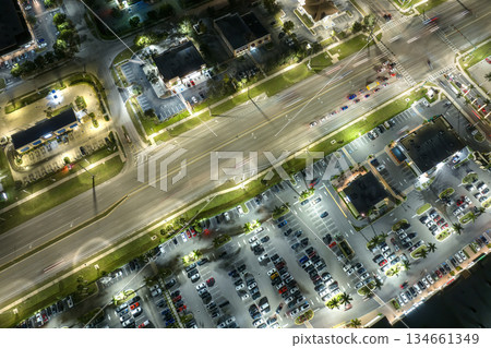 Shopping plaza stores and malls at sunset and American wide highway with many driving cars in North Port, Florida. USA retail and transportation infrastructure Shopping plaza stores and malls at sunset and American wide highway with many driving cars in North Port, Florida. USA retail and transportation infrastructure 134661349