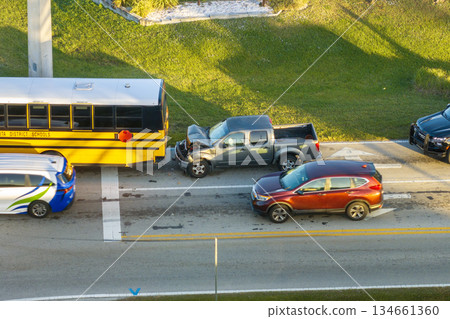 School bus and car accident on American street. Emergency services helping victims of vehicle crash on road in USA School bus and car accident on American street. Emergency services helping victims of vehicle crash on road in USA 134661360