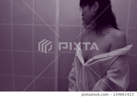 一名成年女性正在脫掉一件白襯衫 134661423