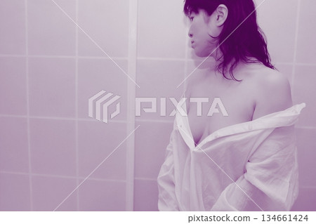 一名成年女性正在脫掉一件白襯衫 134661424