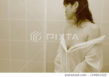 一名成年女性正在脫掉一件白襯衫 134661426