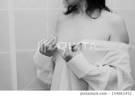An adult woman taking off a white shirt An adult woman taking off a white shirt 134661452