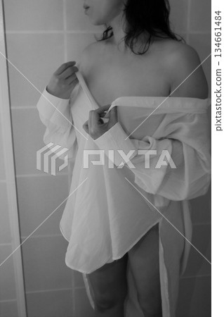 An adult woman taking off a white shirt 134661484