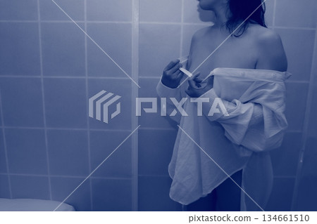 一名成年女性正在脫掉一件白襯衫 一名成年女性正在脫掉一件白襯衫 134661510