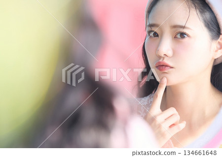 一位年輕漂亮的亞洲女性在鏡子前擺姿勢的美麗肖像 134661648