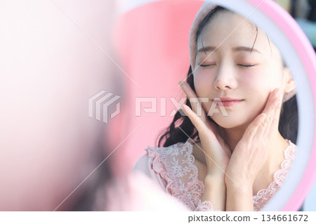 一位年輕漂亮的亞洲女性在鏡子前擺姿勢的美麗肖像 一位年輕漂亮的亞洲女性在鏡子前擺姿勢的美麗肖像 134661672