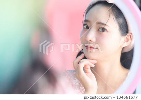Beauty portrait of a young and pretty Asian woman posing in front of a mirror 134661677