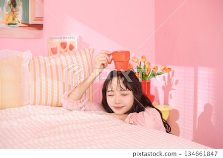Cute portrait of a young woman relaxing in her colorful bedroom 134661847