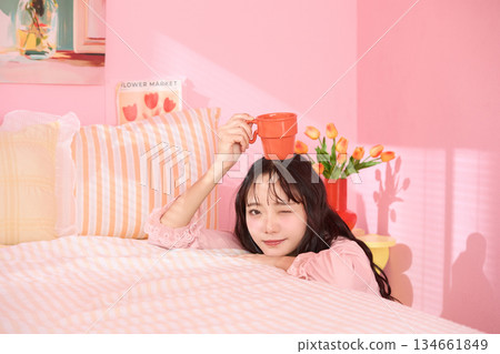 一位年輕女子在色彩繽紛的臥室裡放鬆的可愛肖像 一位年輕女子在色彩繽紛的臥室裡放鬆的可愛肖像 134661849