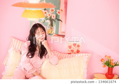 一位年輕女子在色彩繽紛的臥室裡放鬆的可愛肖像 134661874