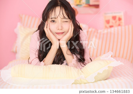 Cute portrait of a young woman relaxing in her colorful bedroom Cute portrait of a young woman relaxing in her colorful bedroom 134661883