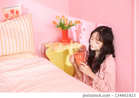 一位年輕女子在色彩繽紛的臥室裡放鬆的可愛肖像 134661923