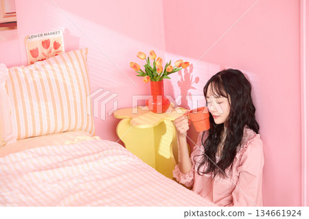 一位年輕女子在色彩繽紛的臥室裡放鬆的可愛肖像 一位年輕女子在色彩繽紛的臥室裡放鬆的可愛肖像 134661924