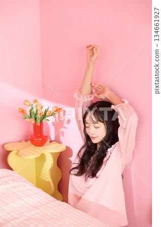 一位年輕女子在色彩繽紛的臥室裡放鬆的可愛肖像 一位年輕女子在色彩繽紛的臥室裡放鬆的可愛肖像 134661927