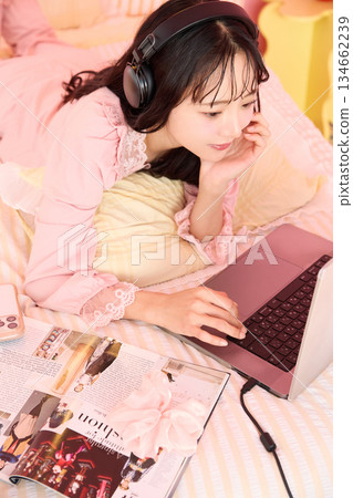Portrait of a young Asian woman relaxing in pajamas in a cute room 134662239