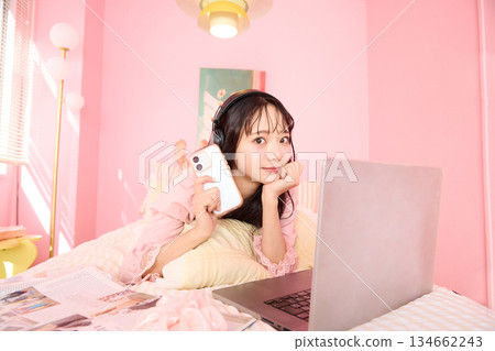 一位年輕的亞洲女性身穿睡衣,在溫馨的房間裡放鬆休息的肖像 一位年輕的亞洲女性身穿睡衣,在溫馨的房間裡放鬆休息的肖像 134662243