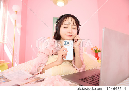 一位年輕的亞洲女性身穿睡衣，在溫馨的房間裡放鬆休息的肖像 134662244