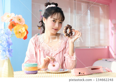 一位可愛女子在色彩繽紛的房間裡吃甜甜圈的肖像 134662248