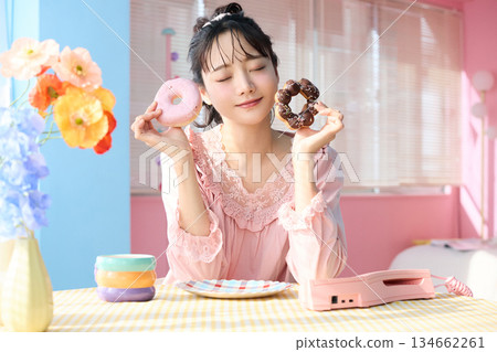 Portrait of a cute woman eating a donut in a colorful room 134662261