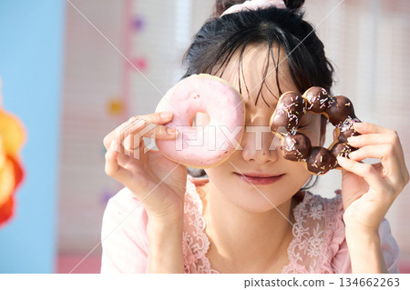 一位可愛女子在色彩繽紛的房間裡吃甜甜圈的肖像 134662263