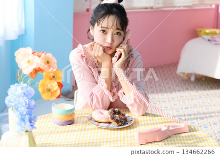 一位可愛女子在色彩繽紛的房間裡吃甜甜圈的肖像 一位可愛女子在色彩繽紛的房間裡吃甜甜圈的肖像 134662266