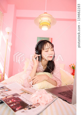 Portrait of a young Asian woman relaxing in pajamas in a cute room 134662283