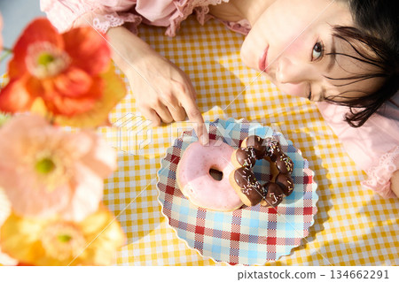 Portrait of a cute woman eating a donut in a colorful room 134662291